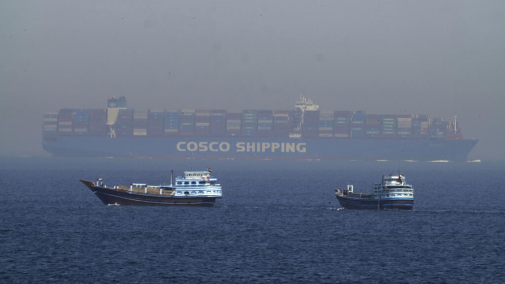 Dhows tradicionales y un buque portacontenedores en el Estrecho de Ormuz, ruta estratégica clave para el comercio mundial de petróleo.