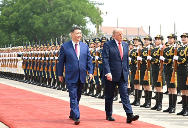 Xi Jinping y Donald Trump caminan sobre una alfombra roja durante una ceremonia oficial de bienvenida en Beijing, frente a una formación de la Guardia de Honor china.