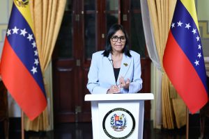 La presidenta Delcy Rodríguez de pie ante un podio con el sello de la Presidencia, flanqueada por dos banderas de Venezuela, durante su alocución del 29 de agosto de 2026.